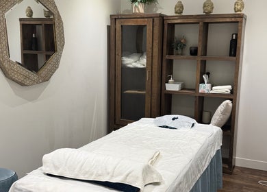 Perth的Health point massage shop宁静房间，配有舒适按摩床和自然装饰。