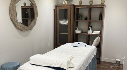 Perth的Health point massage shop宁静房间，配有舒适按摩床和自然装饰。