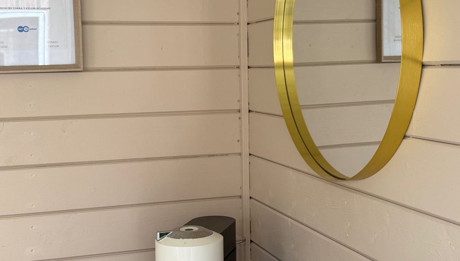 Elegant gold-framed mirror at Nails By Jess, Shireoaks, England, GB on a chic wooden wall.