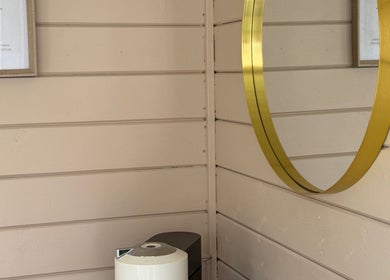 Elegant gold-framed mirror at Nails By Jess, Shireoaks, England, GB on a chic wooden wall.