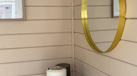 Elegant gold-framed mirror at Nails By Jess, Shireoaks, England, GB on a chic wooden wall.