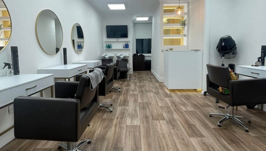 Modern salon interior at JFM hair in Aberdeen, Scotland, GB with sleek styling stations and elegant mirrors.