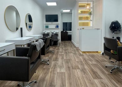 Modern salon interior at JFM hair in Aberdeen, Scotland, GB with sleek styling stations and elegant mirrors.