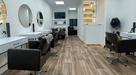 Modern salon interior at JFM hair in Aberdeen, Scotland, GB with sleek styling stations and elegant mirrors.