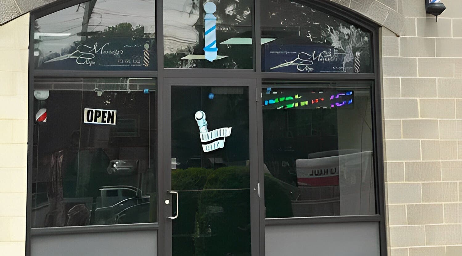 Front entrance of King Mostafa's Clips in Falls Church, Virginia, US featuring a welcoming open sign.