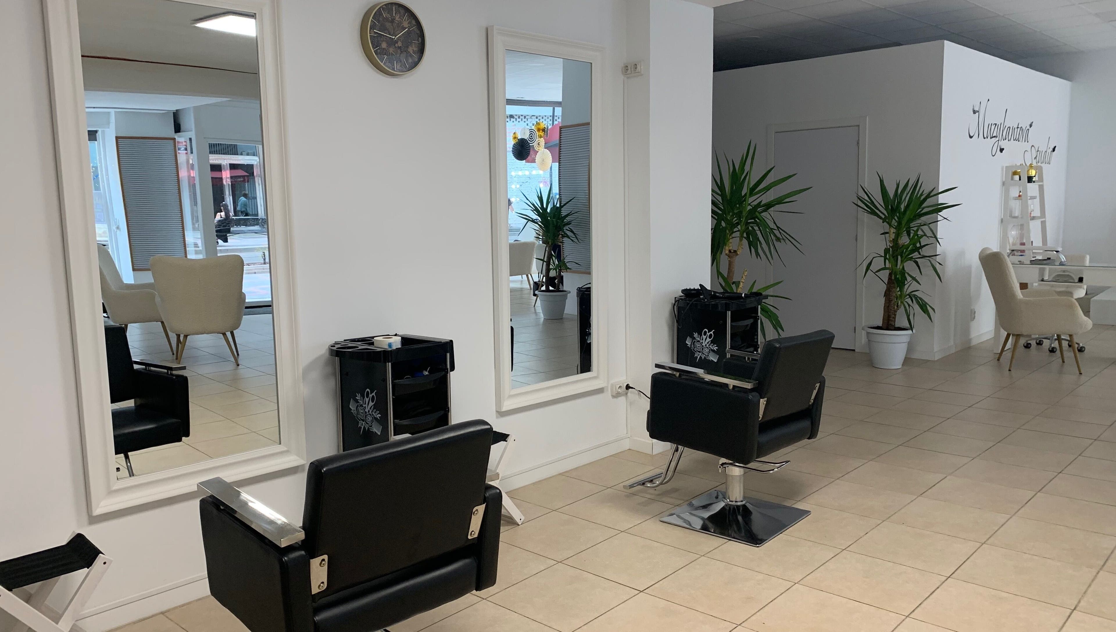 Interior moderno de Laly's Stylist en Fuengirola, Andalucía, ES con espejos y sillas elegantes.