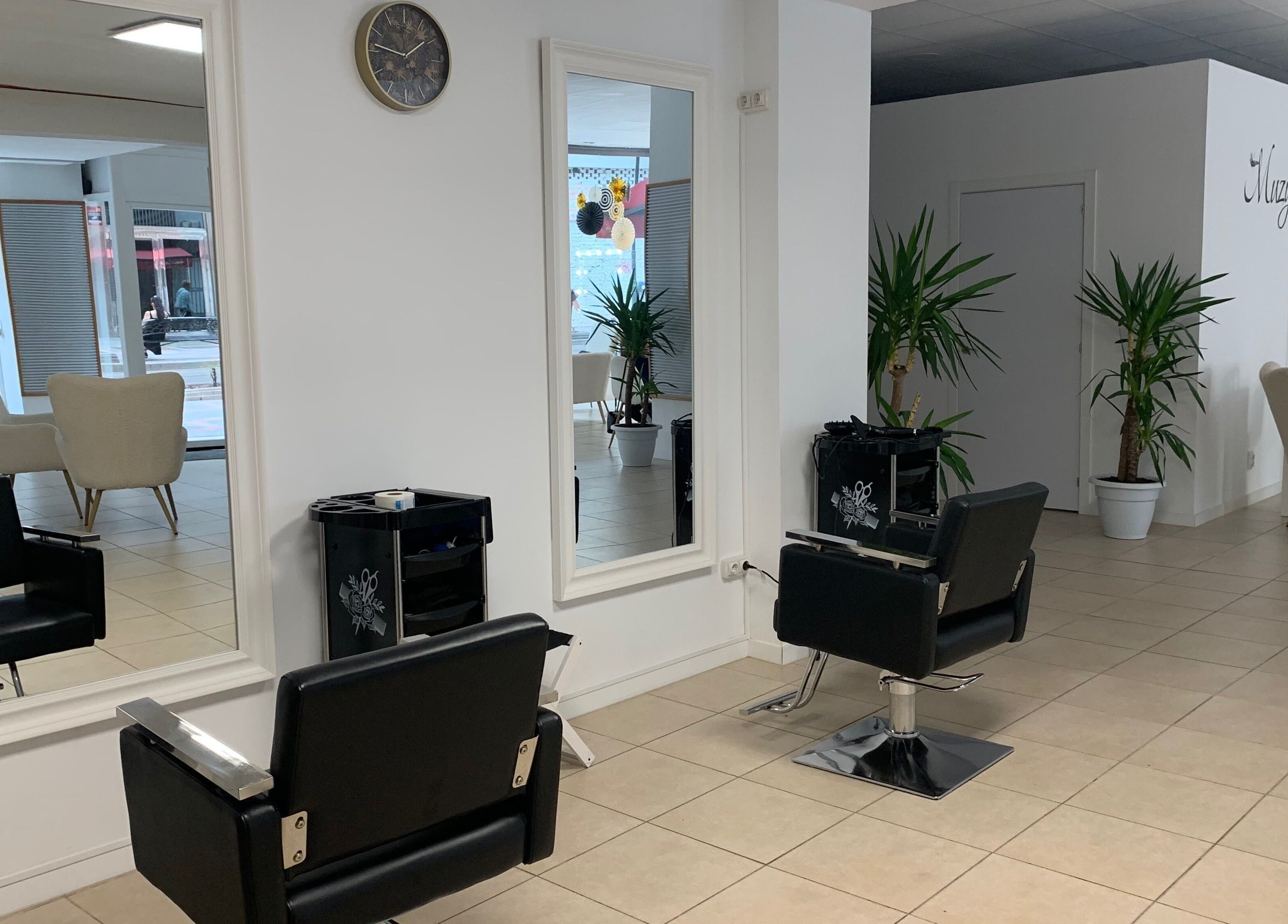 Interior moderno de Laly's Stylist en Fuengirola, Andalucía, ES con espejos y sillas de salón.