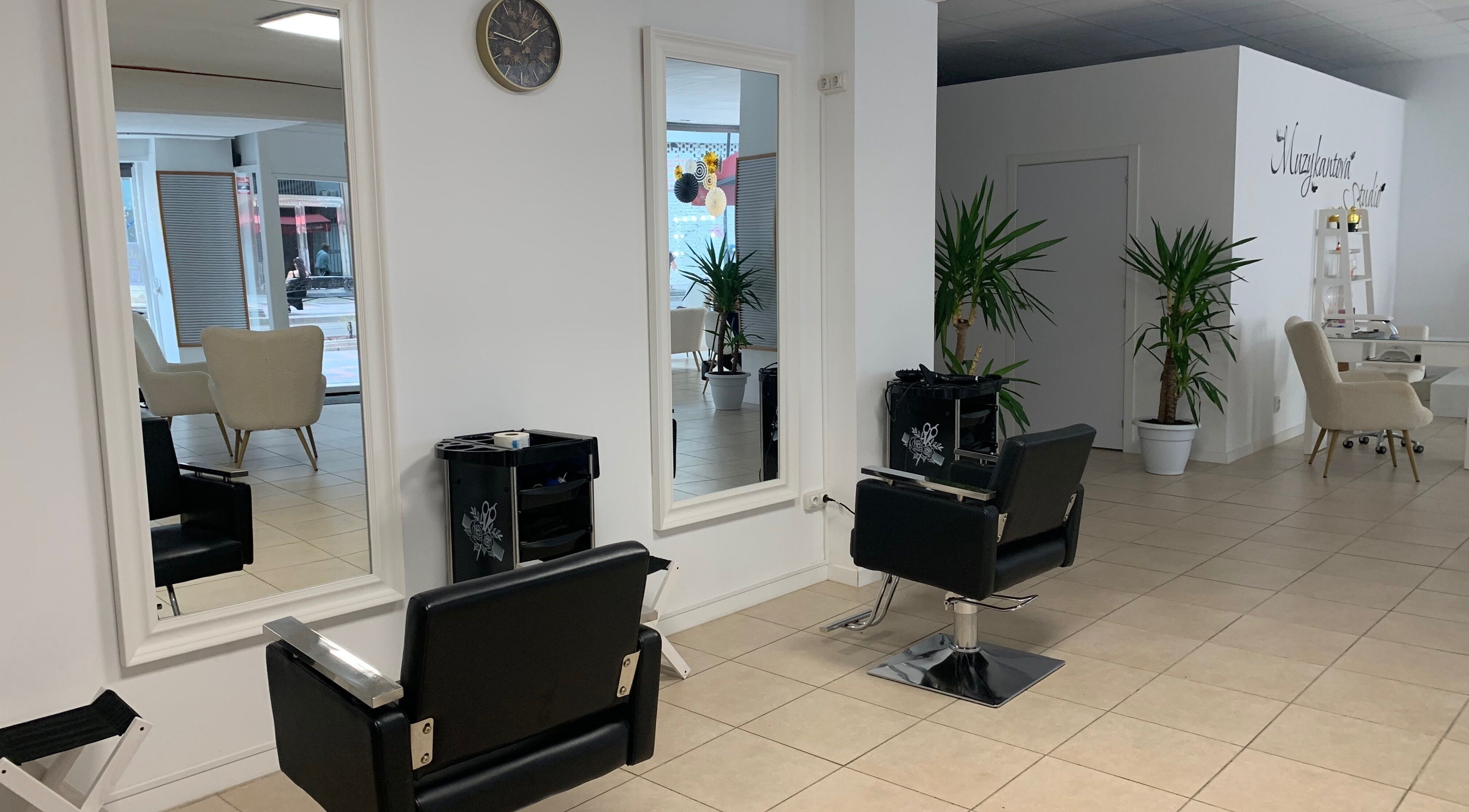 Interior moderno de Laly's Stylist en Fuengirola, Andalucía, ES con espejos y sillas de salón.