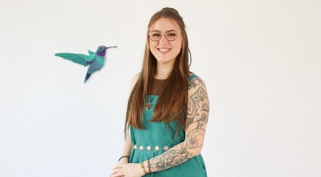 Personne souriante à Colibri, la cabane du bien-être, Henriville, Grand Est, FR avec un tatouage artistique.