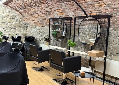 Interno rustico di Sa-Rc Italia Coiffeur Bern, con sedie eleganti e specchi in Bern, Bern, CH.