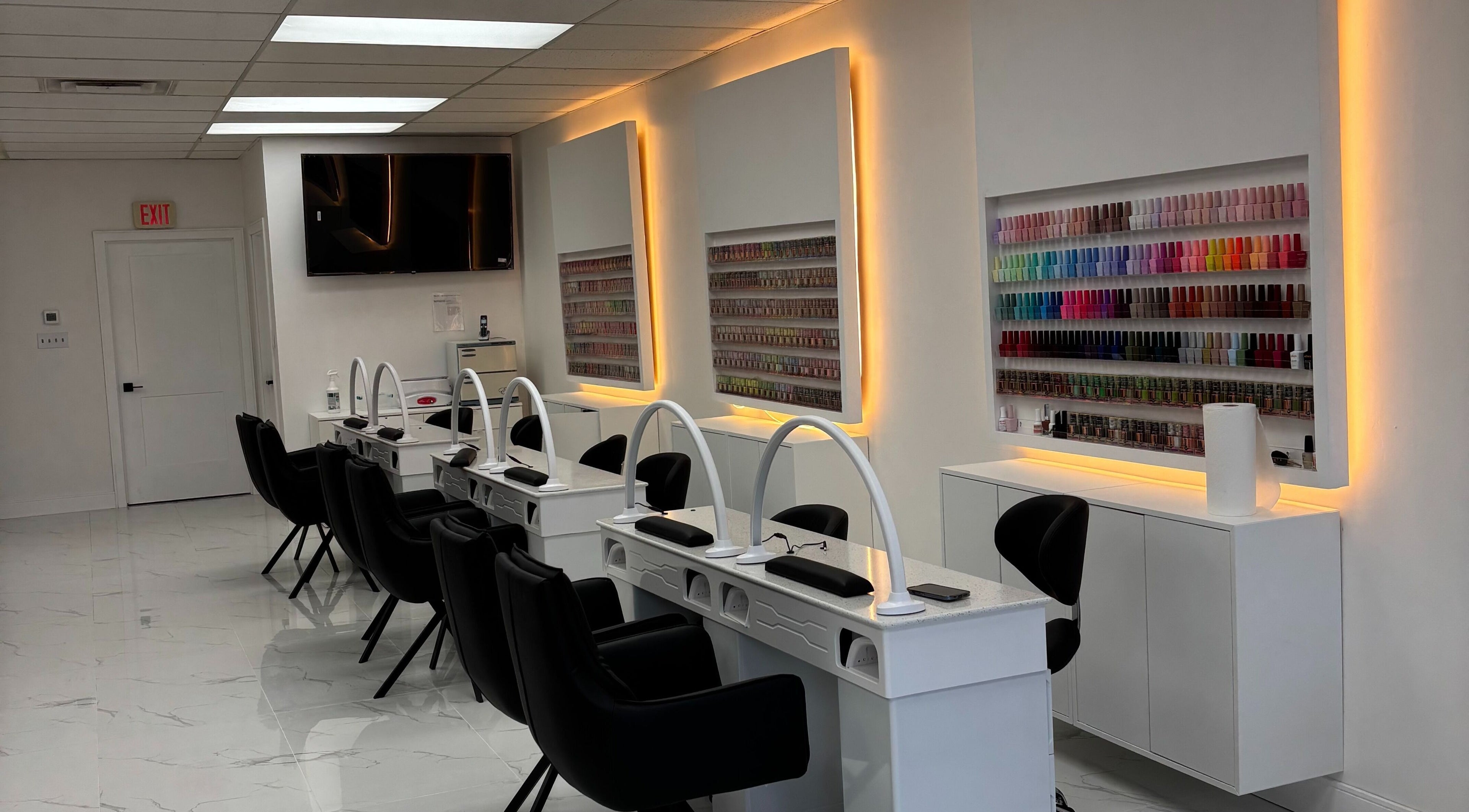 Nail salon interior view at Sunny Nails Guelph, Guelph, Ontario, CA, featuring manicure stations and vibrant polish display.
