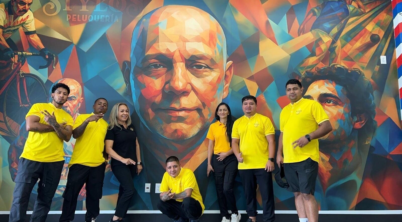 Equipo de Stylos Peluqueria frente a mural colorido en Ladson, South Carolina, US.