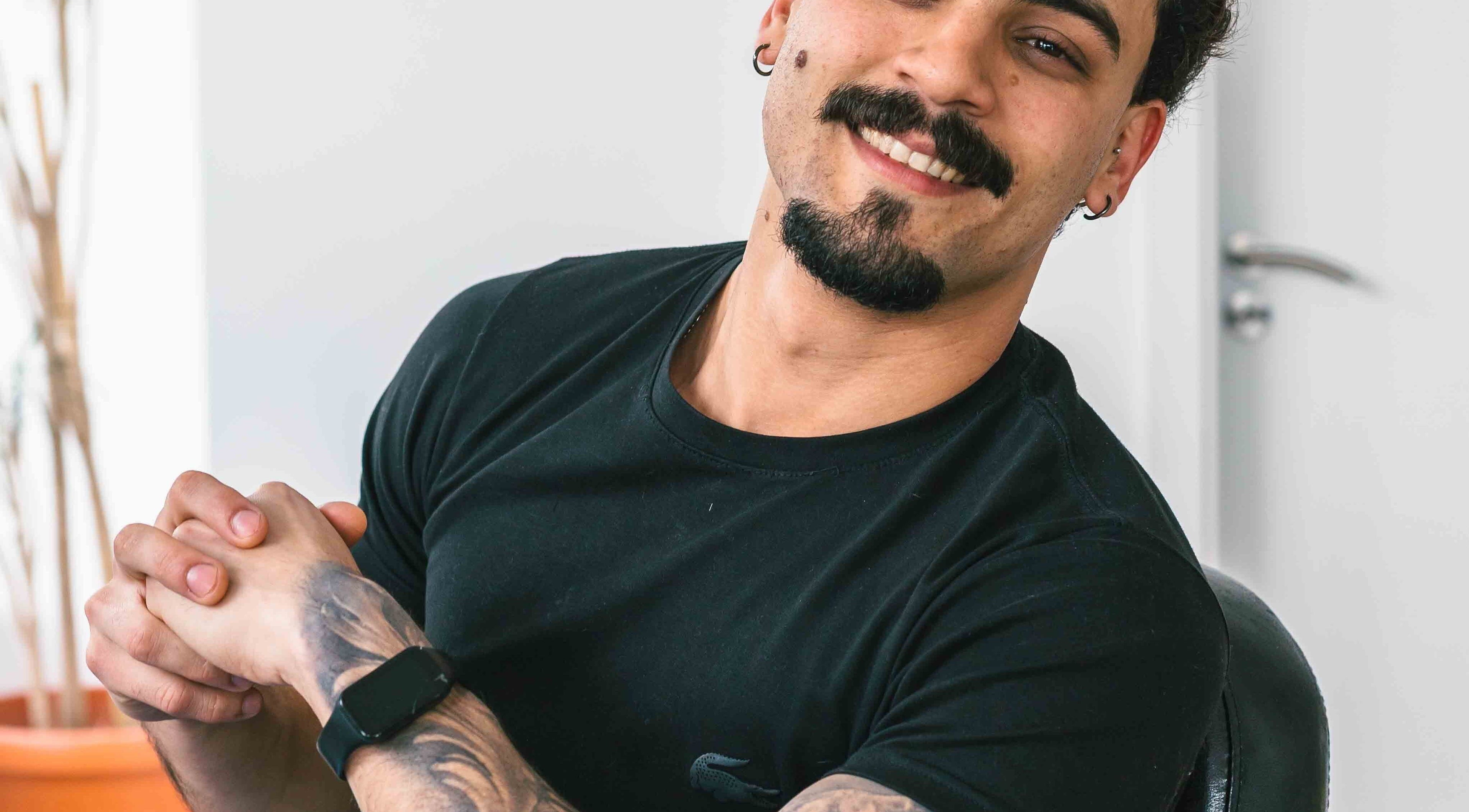 Smiling barber at Carvalho Barbeiro, Vale De Cambra, Aveiro, PT, ready to serve clients.