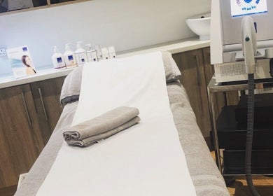 Massage room at Blissful Om Sports Massage, Brighouse, England, GB, with a neatly prepped bed and modern equipment.