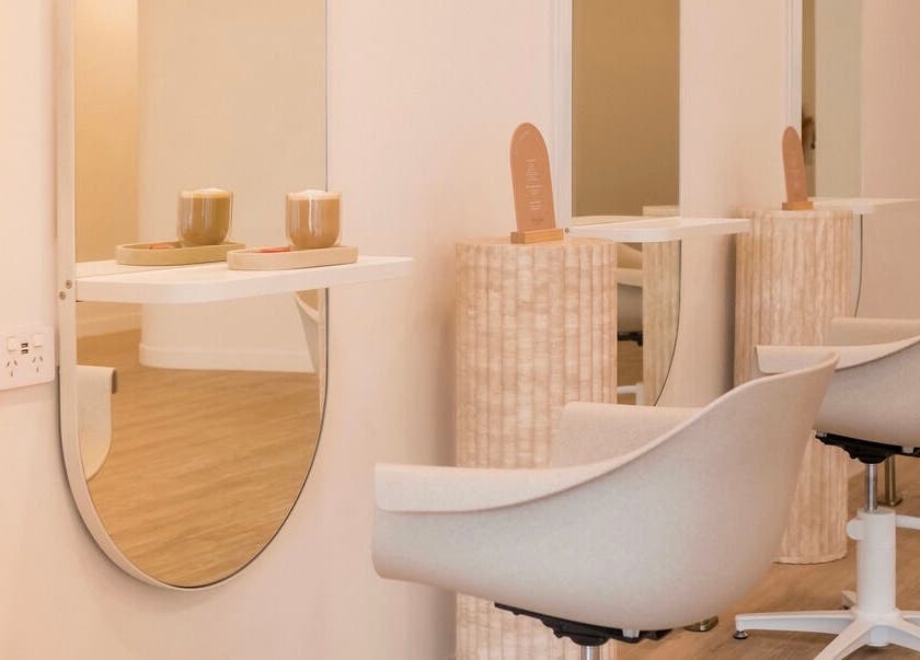 Modern salon chairs and mirrors at Cocoon Hair in Bracken Ridge, Queensland, AU, offering a serene ambiance.