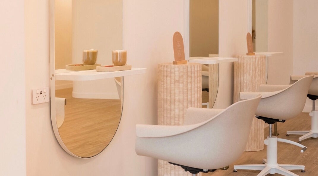 Modern salon chairs and mirrors at Cocoon Hair in Bracken Ridge, Queensland, AU, offering a serene ambiance.