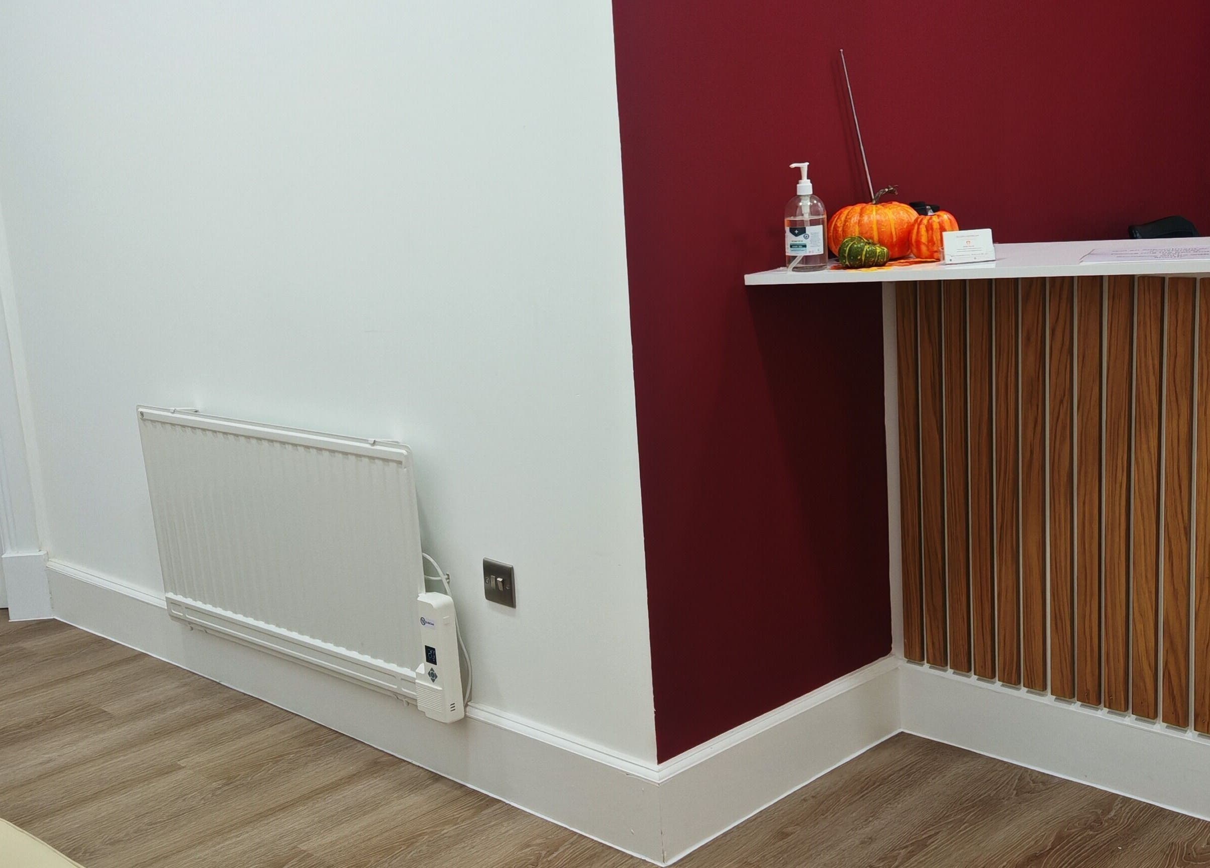 Luxe Ink reception area in Motherwell, Scotland, GB with a modern wood-accented desk and pumpkins.