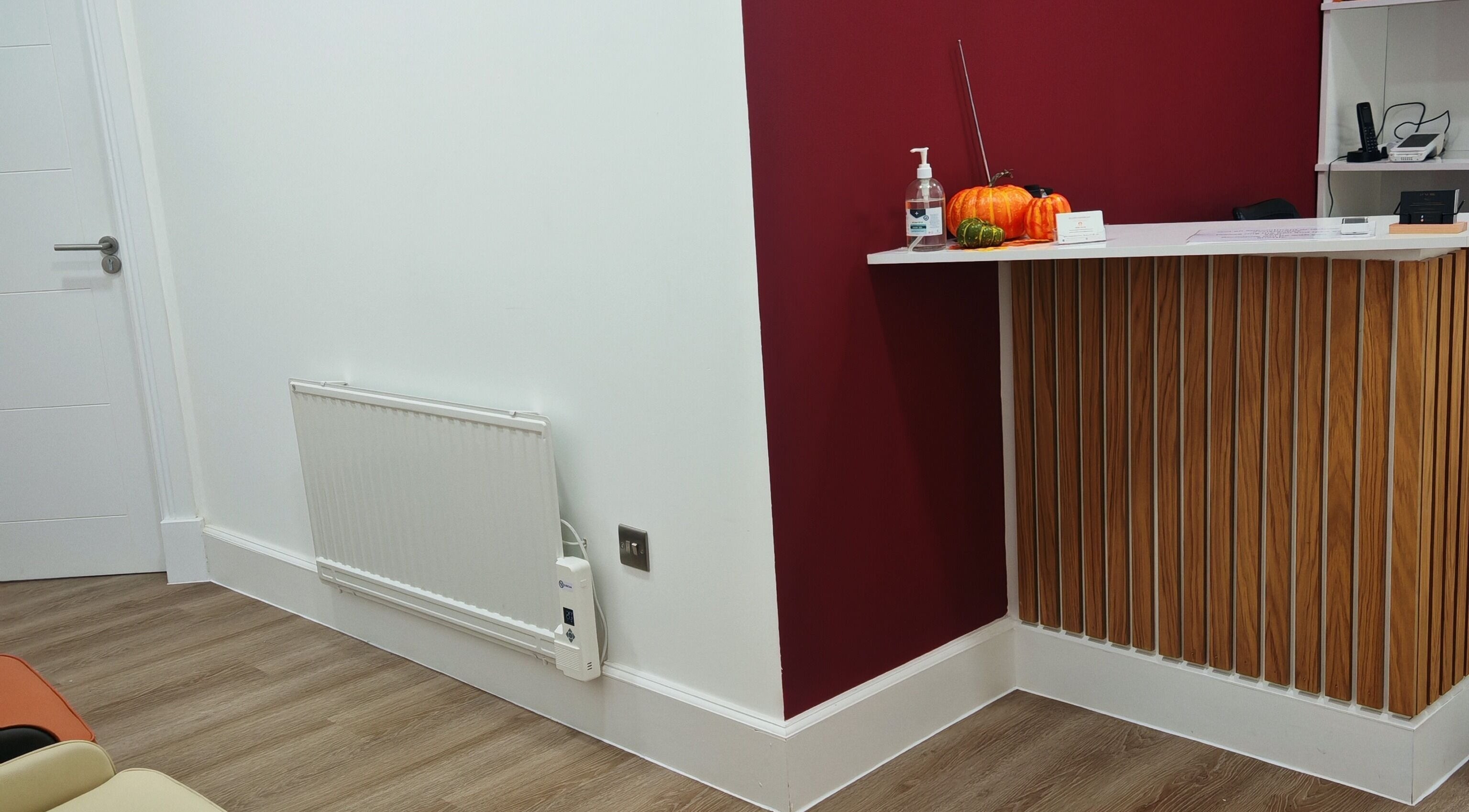Luxe Ink reception area in Motherwell, Scotland, GB with a modern wood-accented desk and pumpkins.