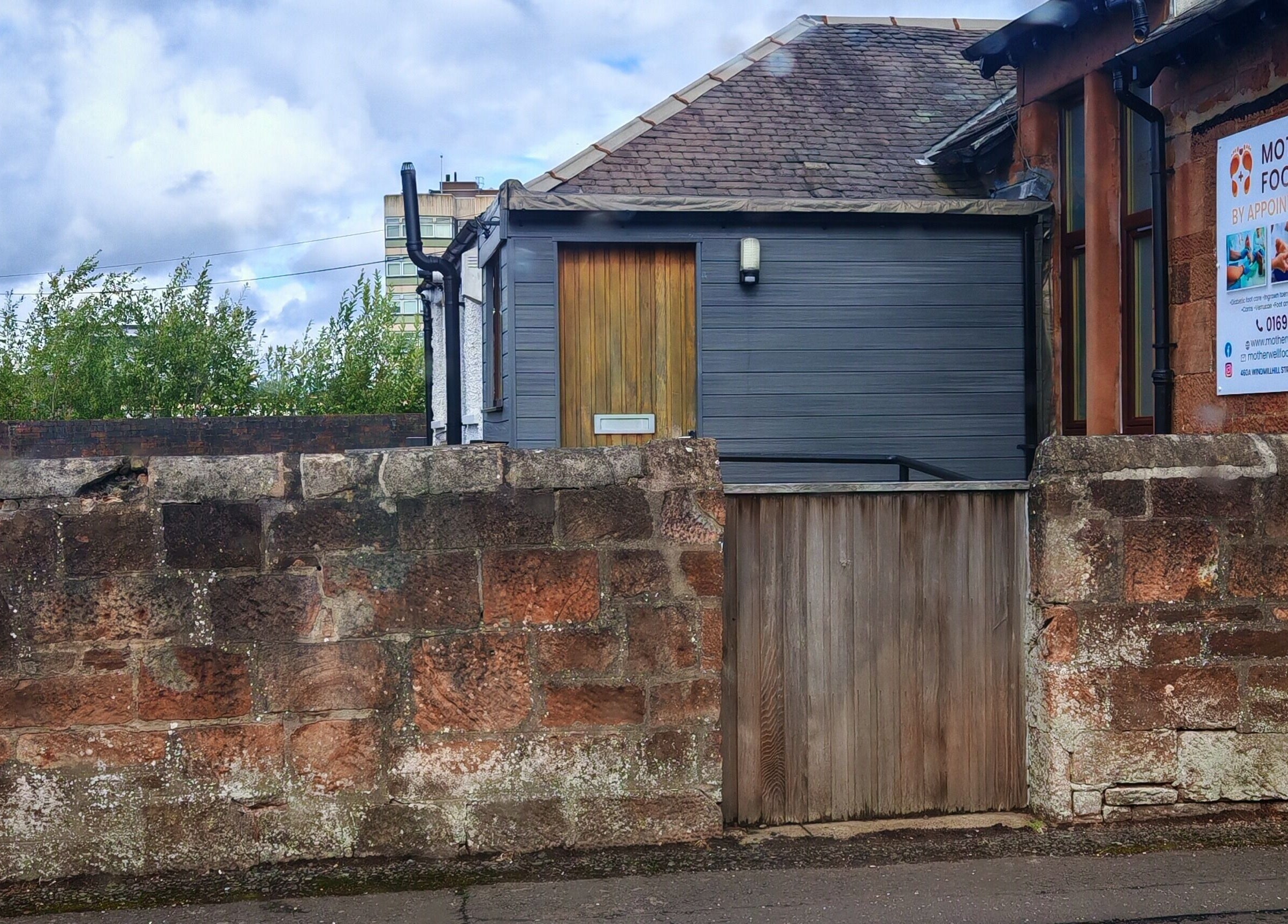 A quaint stone clinic entrance in Motherwell, Scotland, close to Luxe Ink.
