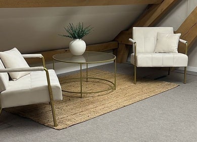 Elegant lounge area at Tommo’s Treatments - Luxe Barn, Tickenham, England. Modern chairs and table under beams.