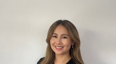 Smiling staff member at Rezai Aesthetics, London, England, GB, offering welcoming service.