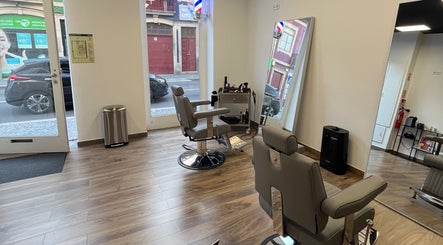 Cadeiras modernas no UNIQ Barbershop em Póvoa De Varzim, Porto, PT, com espelho grande e piso de madeira.