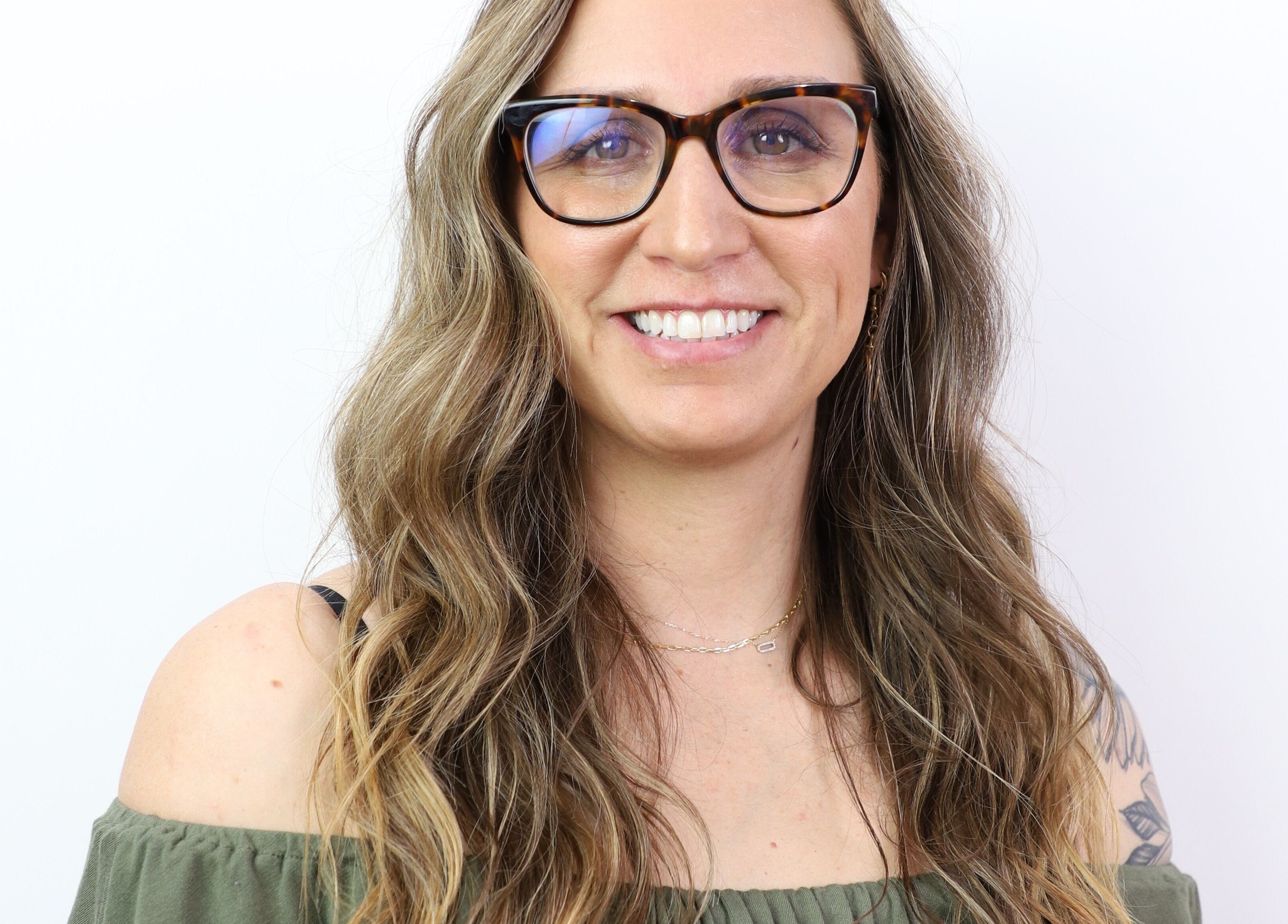 Smiling person with glasses at The Aesthetic Refinery in Orange County, California, US.