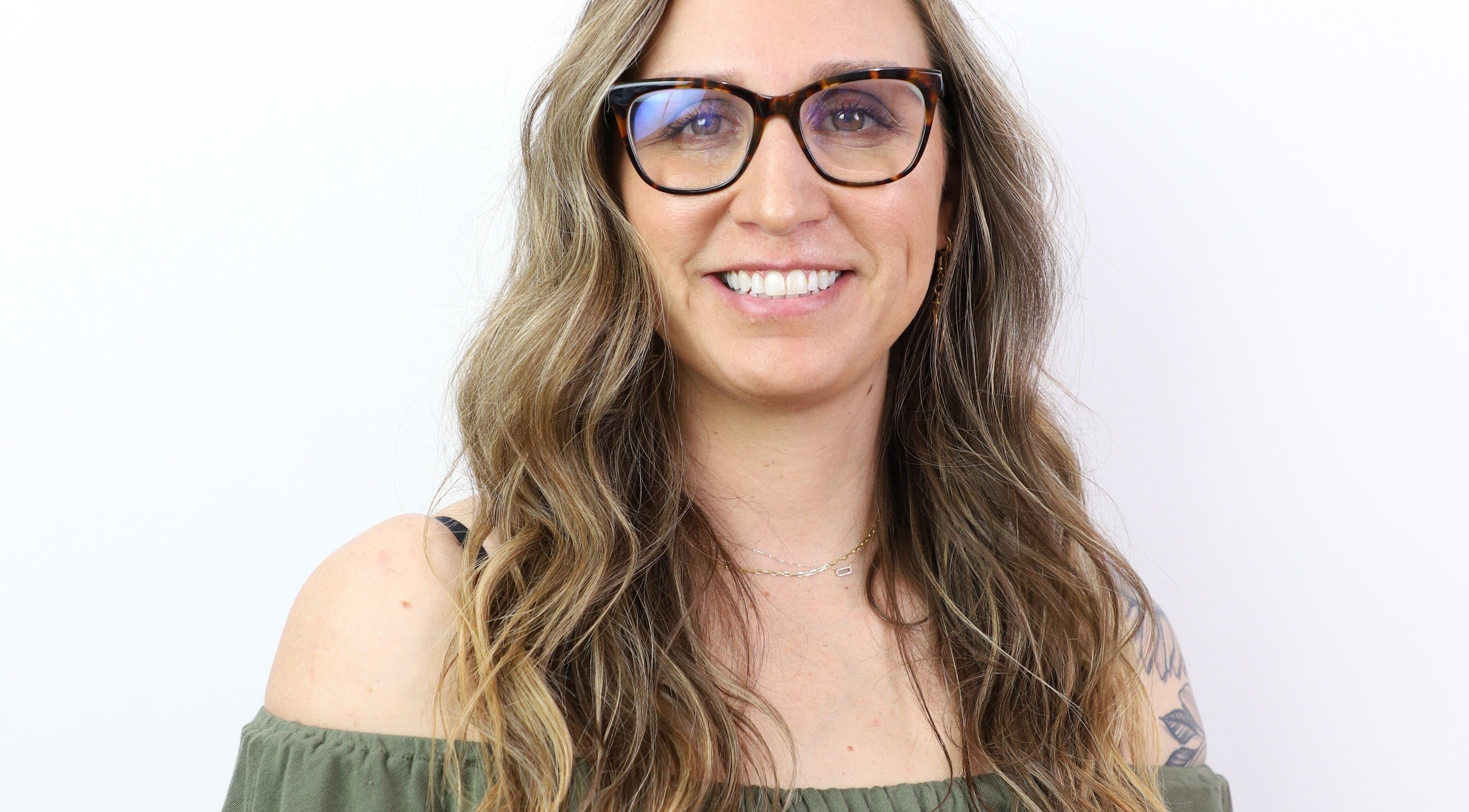 Smiling person with glasses at The Aesthetic Refinery in Orange County, California, US.