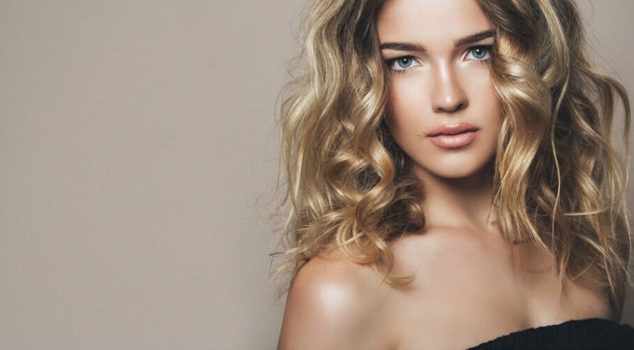 Stylish woman with curly hair embodies Surrey Beauty & Aesthetics, Staines-upon-Thames, England, GB.