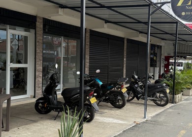 Fachada de Zulbet Diaz Nail Art en Candelaria, CO, mostrada con motos estacionadas al frente.