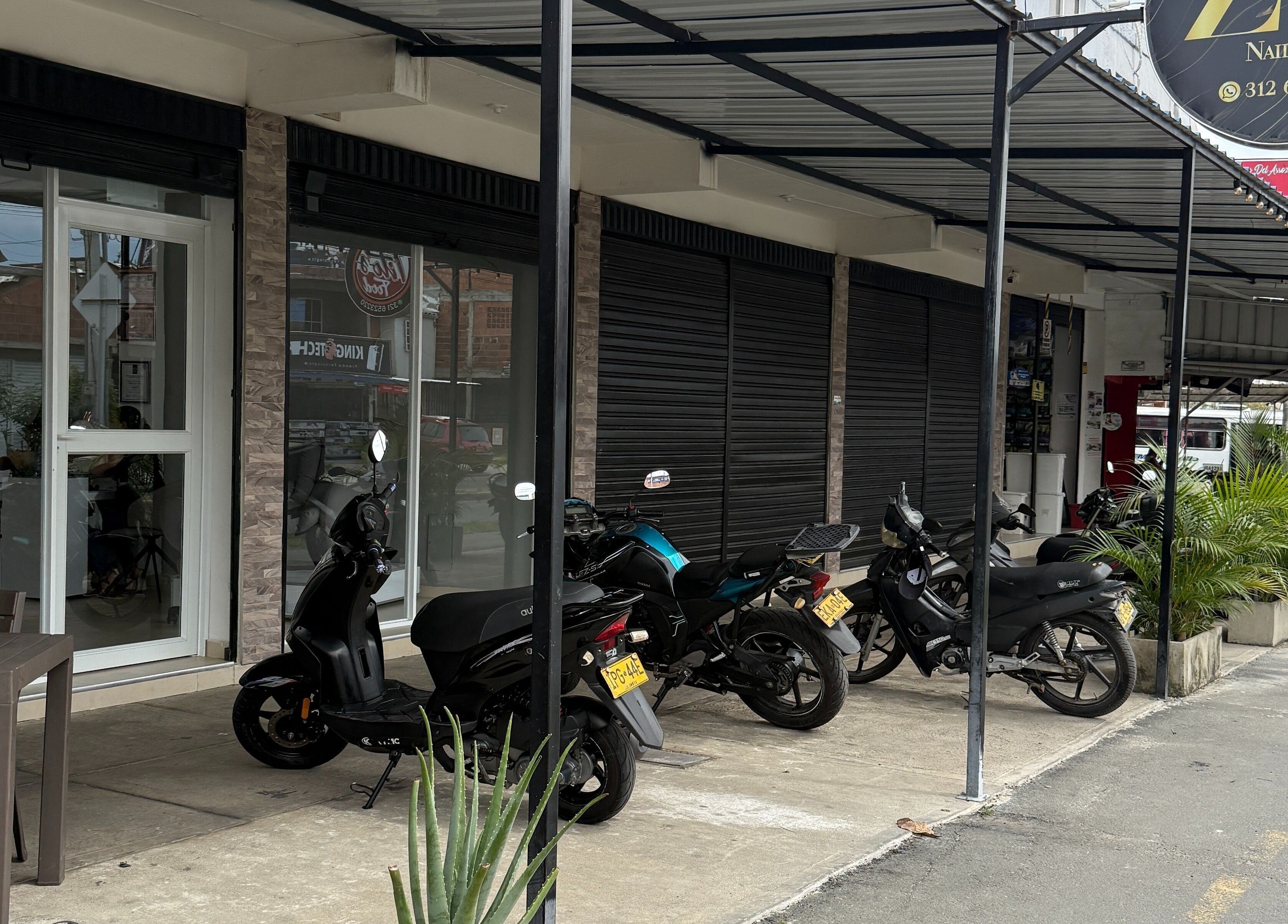 Fachada de Zulbet Diaz Nail Art en Candelaria, CO, mostrada con motos estacionadas al frente.