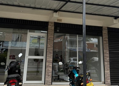 Entrada de Zulbet Diaz Nail Art en Candelaria, CO, con scooters estacionados enfrente.