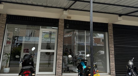 Entrada de Zulbet Diaz Nail Art en Candelaria, CO, con scooters estacionados enfrente.