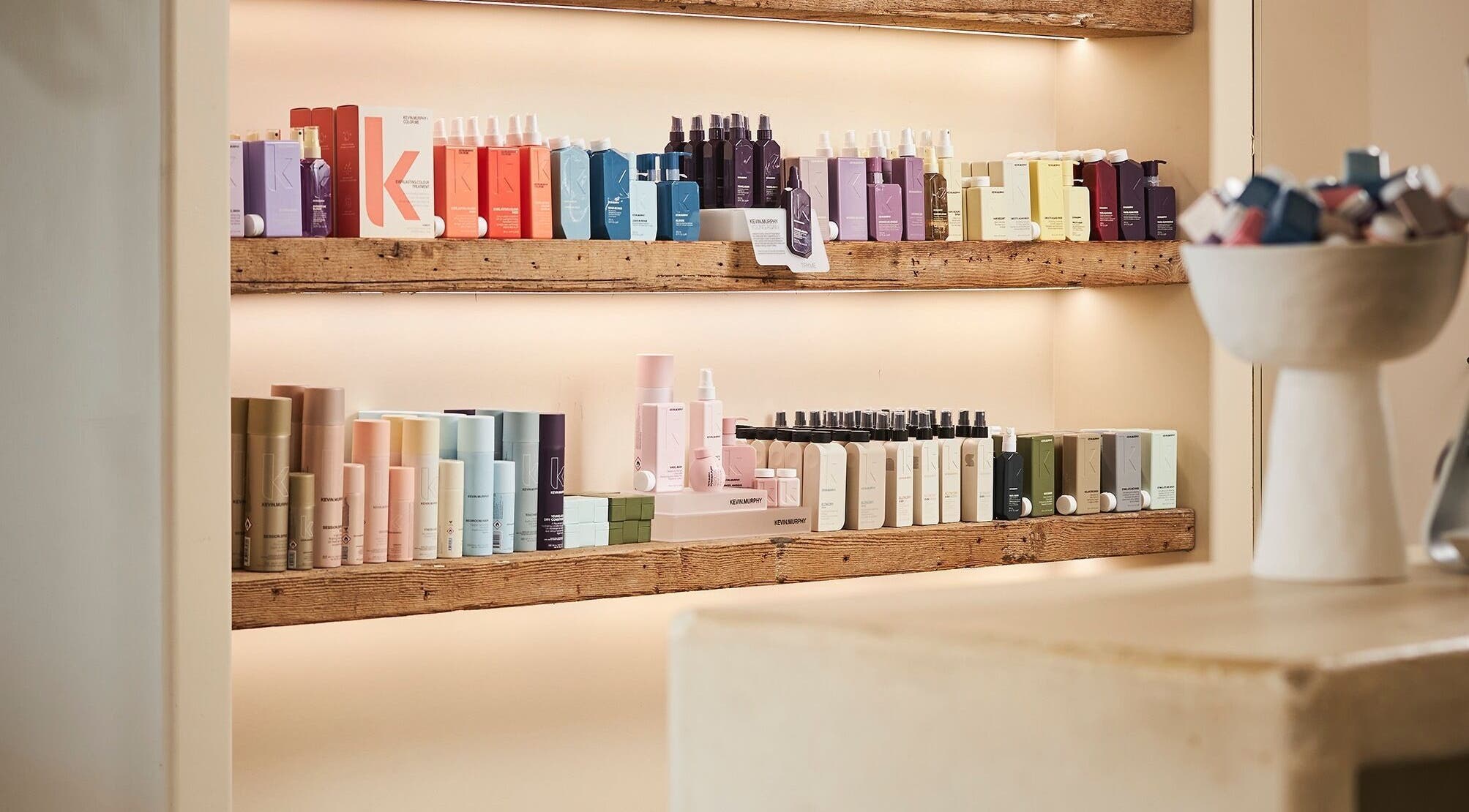 Diverse hair care products neatly displayed on shelves at Fuchs Hair, Alexandria, New South Wales, AU.