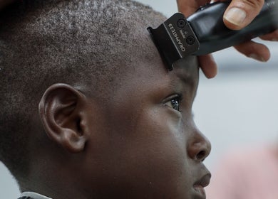 Child receiving a haircut at Image Unisex Barbershop and Salon, Sicklerville, New Jersey, US.