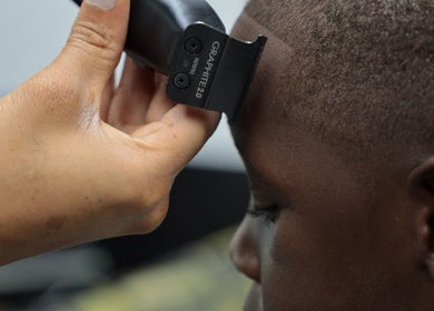 Expert barber using clippers at Image Unisex Barbershop and Salon, Sicklerville, New Jersey, US.