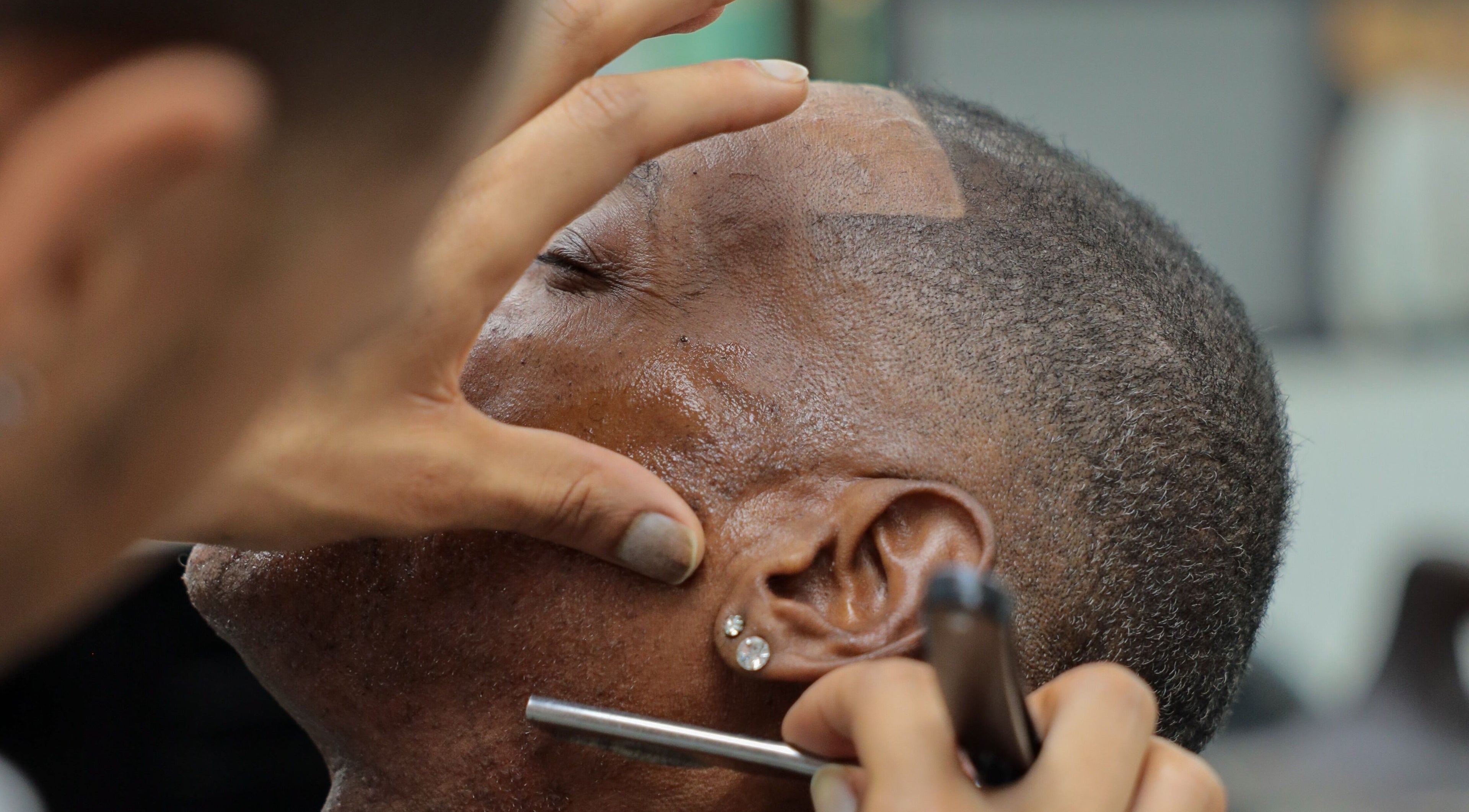Expert barber shaving client at Image Unisex Barbershop and Salon, Sicklerville, New Jersey, US.