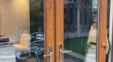 Calming entrance of Honey's Haven in Rotherham, England, GB featuring glass doors and cozy outdoor seating.