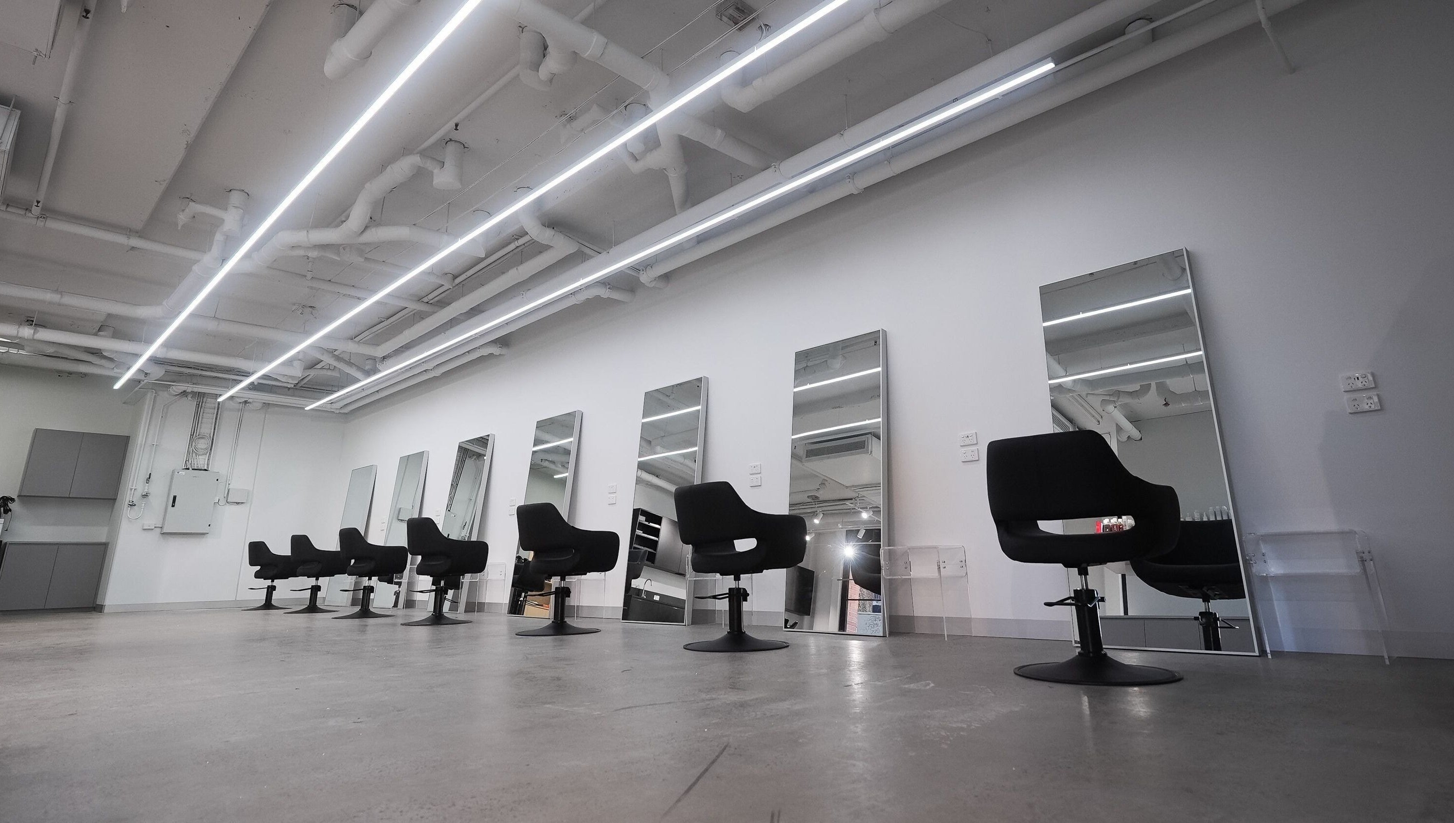 Modern salon interior at ASSORT HAIR PTY LTD, Melbourne, Victoria, AU, featuring stylish chairs and mirrors.