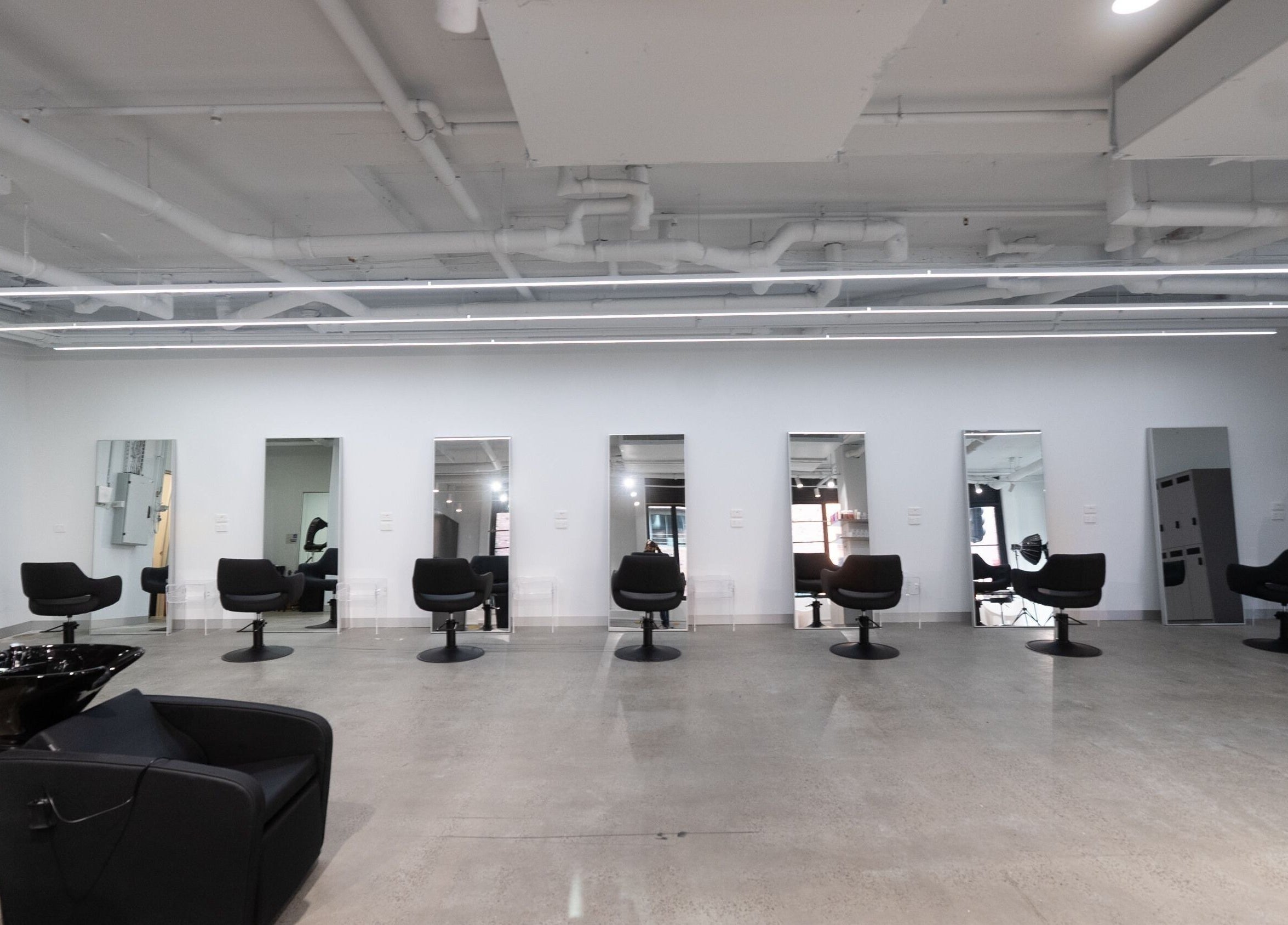 Interior of ASSORT HAIR PTY LTD salon with sleek chairs and mirrors in Melbourne, Victoria, AU.