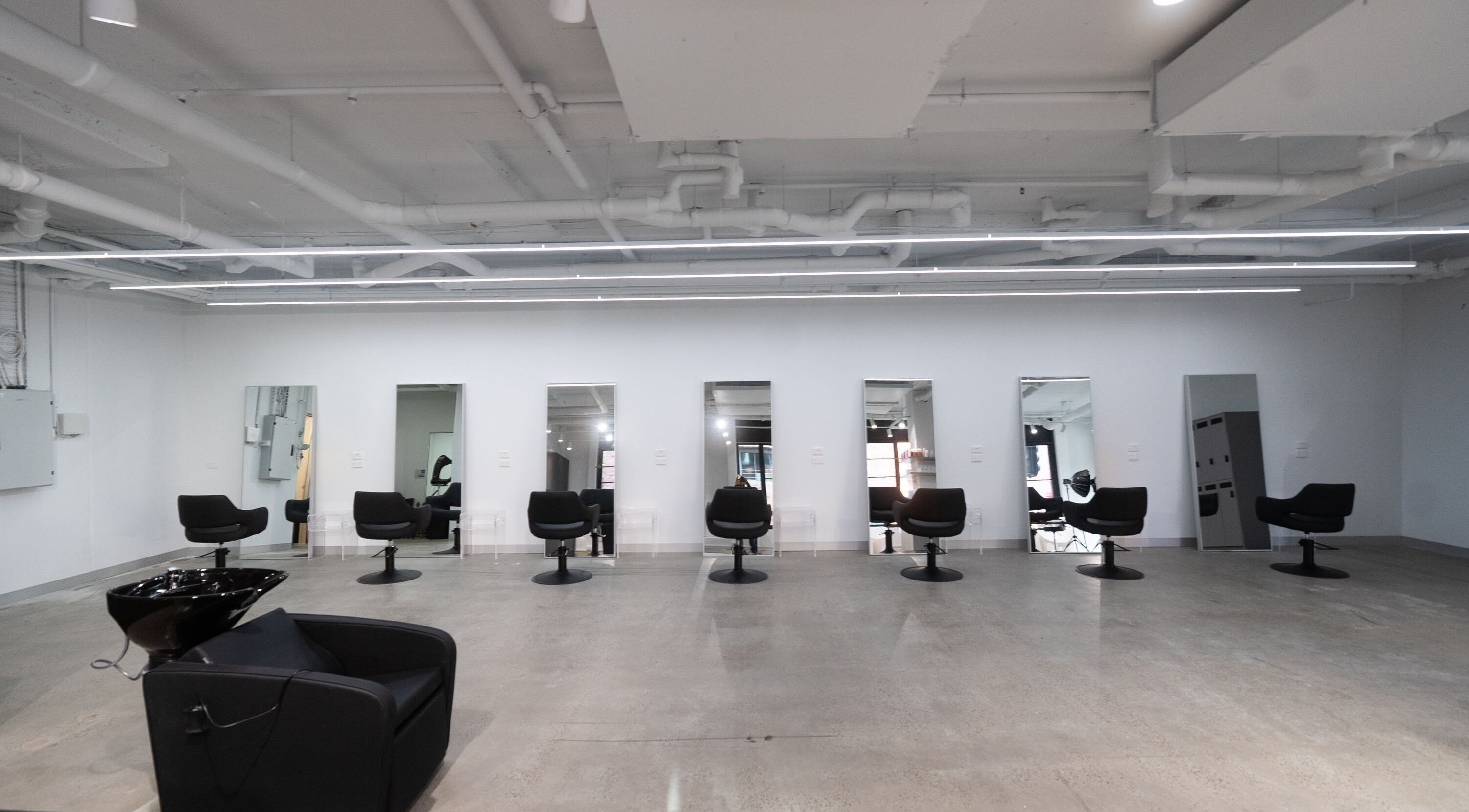 Interior of ASSORT HAIR PTY LTD salon with sleek chairs and mirrors in Melbourne, Victoria, AU.