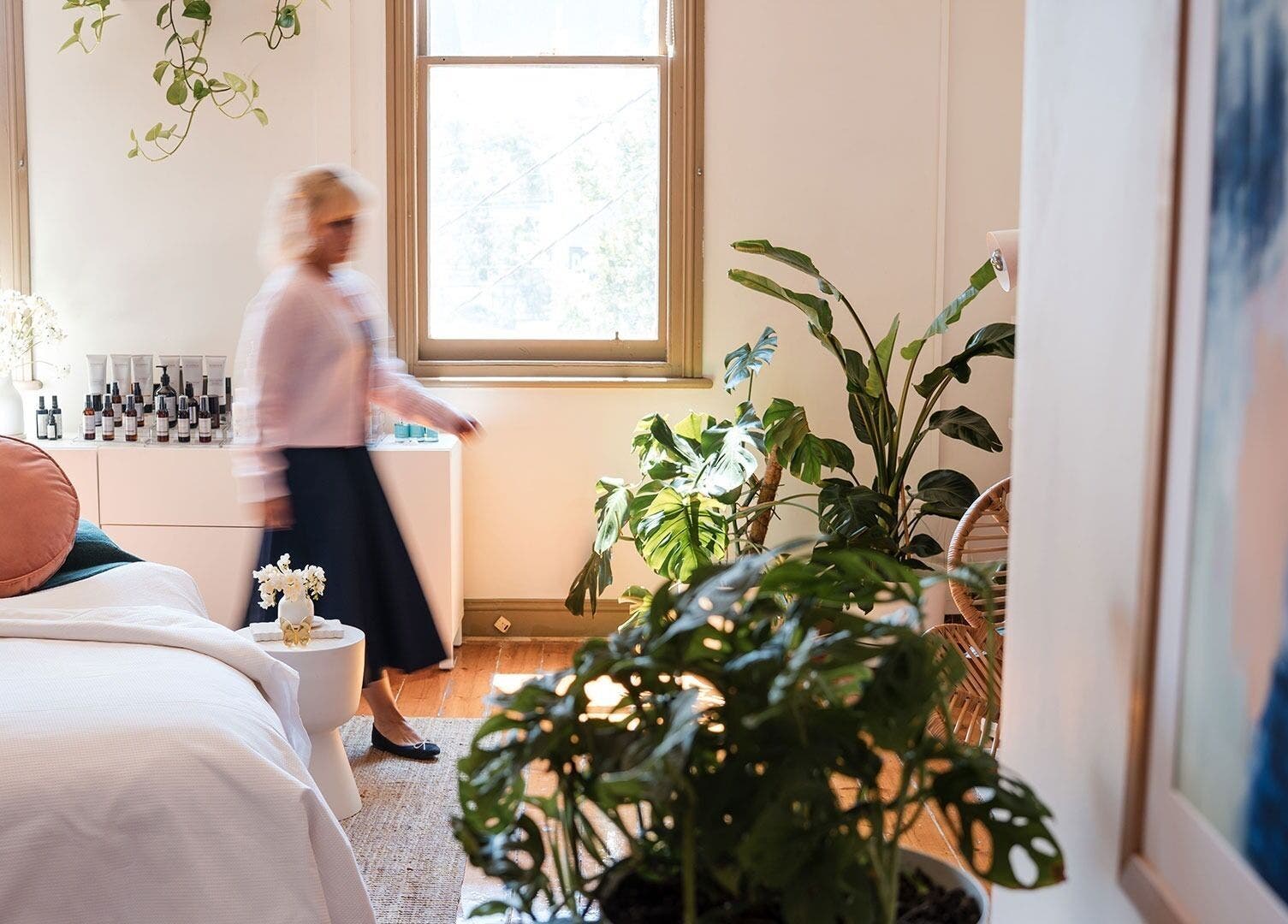 Bright, lush spa room at The Peaceful Skin Co, Melbourne, Victoria, AU with plants and a cozy treatment bed.