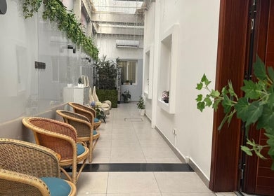 ممر داخلي أنيق في صالون ريما بجدة، منطقة مكة المكرمة، السعودية، مزين بالنباتات والكراسي.