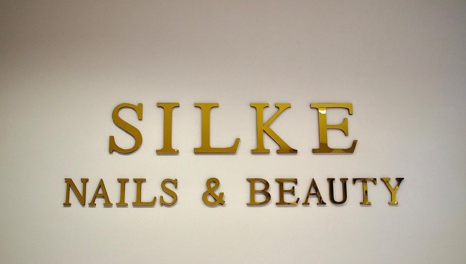 Gouden logo van Silke Nails & Beauty op de muur te Bolsward, Friesland, NL.