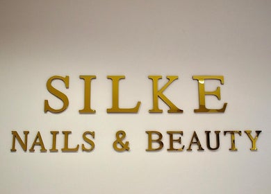 Gouden logo van Silke Nails & Beauty op de muur te Bolsward, Friesland, NL.