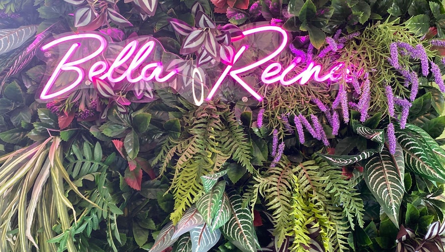 Neon Bella Reina aesthetics sign amidst lush greenery at Bridgwater, England, GB venue.