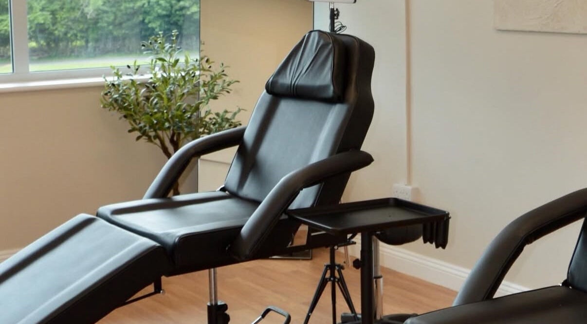 Relaxing black treatment chair at Calla Lounge, Plymouth, England, GB near a large window with greenery.