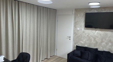 Elegantan kutak u Amber beauty lounge, Zagreb, Grad Zagreb, HR, s crnim kaučem i televizorom.
