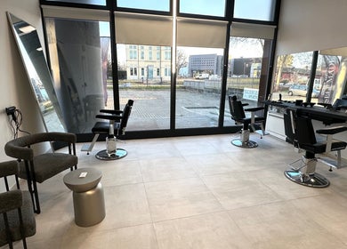 L'interno di Andrea Manfredi Barber presso Avelino Barbershop a Parma, Emilia-romagna, IT, con sedie moderne.