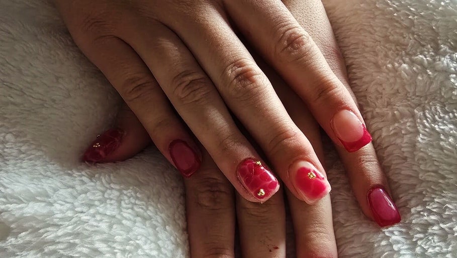 Stylish red manicured nails at NailsByKrista in Newmarket, England, GB showcasing elegant designs.